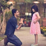 a man kneeling on his knee and holding his hand up to a girl