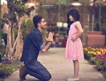 a man kneeling on his knee and holding his hand up to a girl